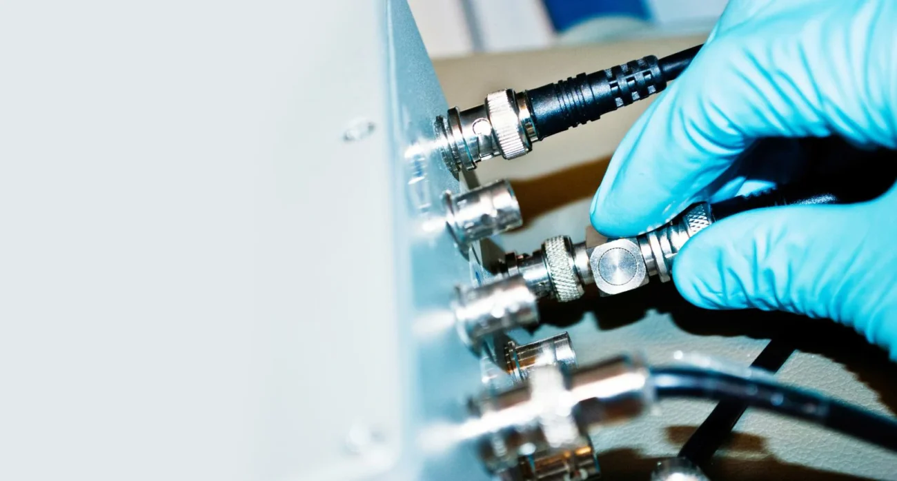 Engineer connecting a BNC RF adapter to laboratory test equipment Engineer connecting a BNC RF adapter to laboratory test equipment