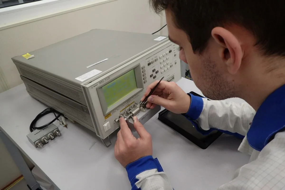 Engineer testing a BNC adapter with RF laboratory measurement equipment Engineer testing a BNC adapter with RF laboratory measurement equipment