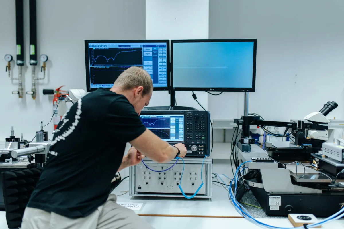 Engineer testing an RF cable assembly with a vector network analyzer in a laboratory Engineer testing an RF cable assembly with a vector network analyzer in a laboratory