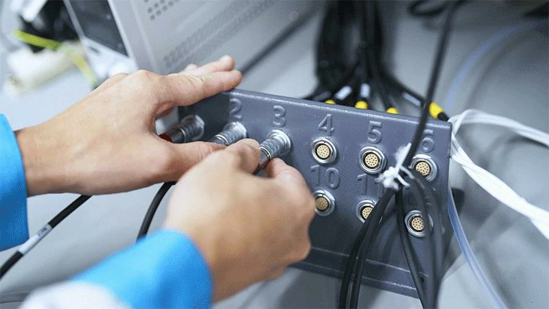 Technician installing RF connectors on an equipment connection panel Technician installing RF connectors on an equipment connection panel