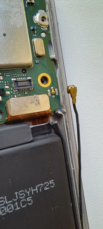 Disconnected U.FL IPEX micro coax cable inside a compact electronic device during repair Disconnected U.FL IPEX micro coax cable inside a compact electronic device during repair