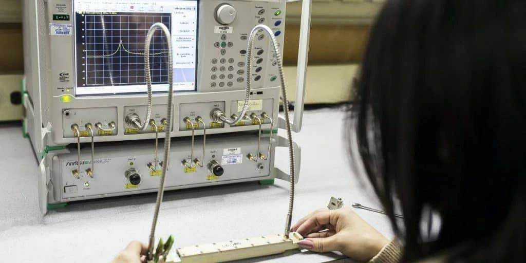 Engineer testing an RF cable assembly with a vector network analyzer Engineer testing an RF cable assembly with a vector network analyzer